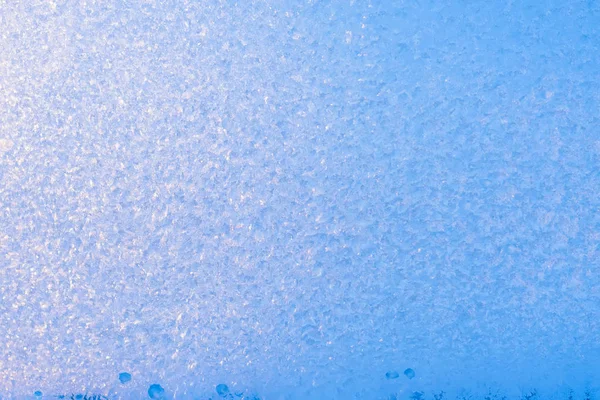 Background of frozen window glass, very strong frost and cold, texture in blue color, copy space