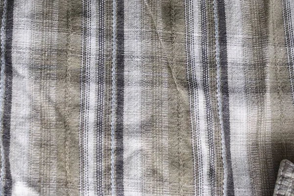 Close up part of a shirt from hemp fabric. Casual man's shirt with pattern. Wrinkled texture from hemp and cotton background