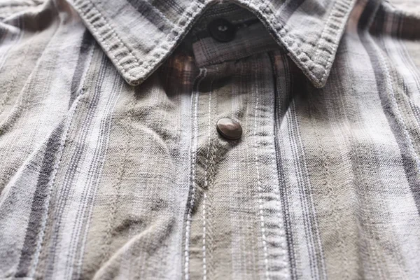 Close up part of a shirt from hemp fabric. Casual man\'s shirt with pattern. Wrinkled texture from hemp and cotton background