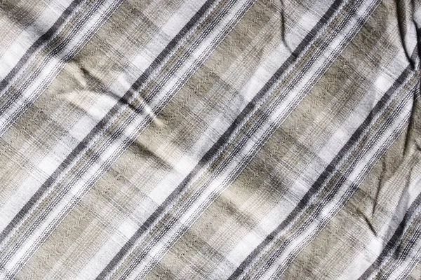 Close up part of a shirt from hemp fabric. Casual man\'s shirt with pattern. Wrinkled texture from hemp and cotton background