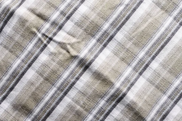 Close up part of a shirt from hemp fabric. Casual man\'s shirt with pattern. Wrinkled texture from hemp and cotton background