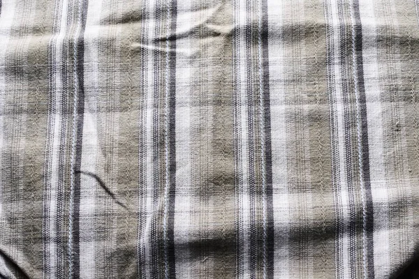 Close up part of a shirt from hemp fabric. Casual man\'s shirt with pattern. Wrinkled texture from hemp and cotton background