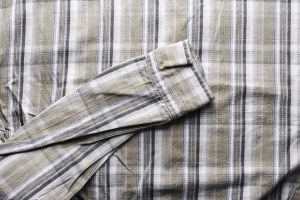 Close up part of a shirt from hemp fabric. Casual man\'s shirt with pattern. Wrinkled texture from hemp and cotton background