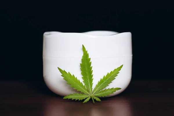 Jar of hemp white lotion. Detail of cannabis cream with marijuan