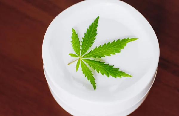 Jar of hemp white lotion. Detail of cannabis cream with marijuan