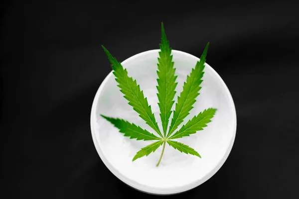 Draufsicht auf ein Glas mit cbd oder Hanfsalbe mit Cannabisblatt auf b — Stockfoto