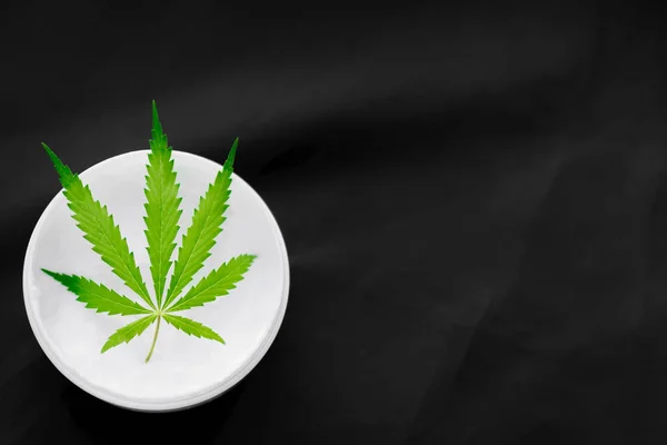 Pohled na džbánek s CBD nebo konopím, ve kterém se nachází Cannabis list na b — Stock fotografie