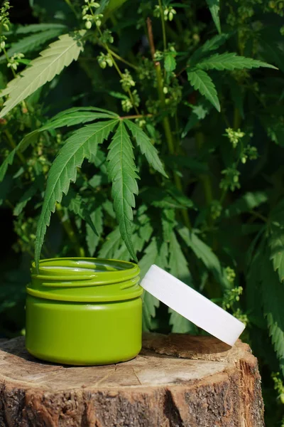 Jar of hemp lotion on blurry background with copy space. Cannabi — Stock Photo, Image