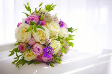 Taze kesilmiş güllerden bir buket çiçek ve diğer güzel çiçekler kompozisyonda.