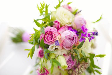 Altın alyansları kapatın genç ve taze çiçek buketleri ve diğer çiçek açan güzel çiçekler.