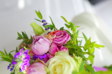 Altın alyansları kapatın genç ve taze çiçek buketleri ve diğer çiçek açan güzel çiçekler.