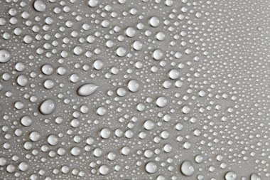 Çok fazla su damlası var. Soyut arkaplan dokusu. Sağlam bir zemin üzerinde şelaleler, temiz bir yüzey üzerinde kabarcıklar topluyor. Yağmur damlaları, bir dizi doğal fotoğraf.