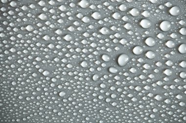 Çok fazla su damlası var. Soyut arkaplan dokusu. Sağlam bir zemin üzerinde şelaleler, temiz bir yüzey üzerinde kabarcıklar topluyor. Yağmur damlaları, bir dizi doğal fotoğraf.