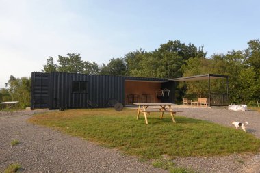 Çağdaş konteynır evi açık-plan tasarımı sunuyor, kapalı ve açık alanda birleşiyor bir teras alanı ve çevreleyen yeşillik ile yaşıyor.