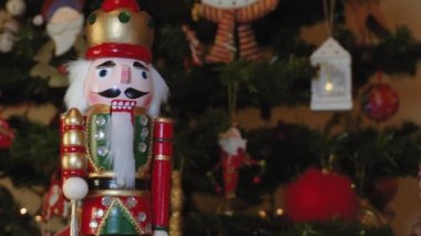 Büyük tin Fındıkkıran asker bir Noel ağacı ile arka plan bulanık. Mevsimlik oyuncak figür ışıklı bir yapay Noel ağacı ışıkları ve renkli süslemeleri ile önce. 