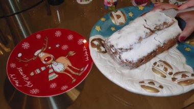 Erkek Stollen Noel geleneksel Alman badem ezmesi kek bir tabak üzerinde keser. El meyve mevsimlik ekmek Kuruyemiş, baharat ve pudra şekeri ile şenlikli bir tabak üzerinde kesin bir dilim keser.
