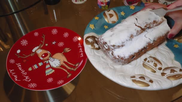 女性削减肿胀圣诞节传统的德国马子潘蛋糕在一道菜上 手工切水果时令面包 有坚果 香料和糖粉 在节日的盘子上切一片 — 图库视频影像