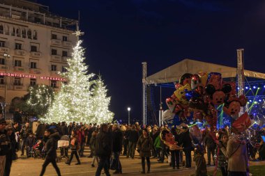 Thessaloniki, Greece - December 24 2018: Christmas 2018 decorations at Aristotelous square. Evening view of unidentified crowd around the main illuminated tree at the central city square. clipart
