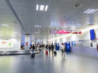 Bergamo, İtalya - 16 Temmuz 2018: Yolcular Milano Bergamo Havaalanı Bagaj talep yürü. Orio al Serio Caravaggio Uluslararası Havaalanı geliş alanının, Bagaj ile tanımlanamayan seyahat etmek.