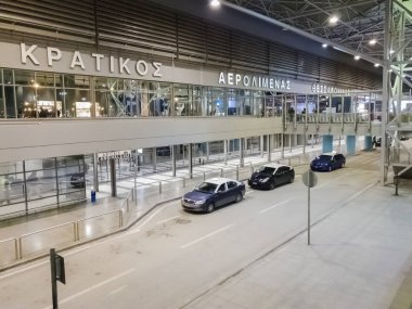 Thessaloniki, Yunanistan - 12 Ocak 2019: Thessaloniki Skg Havaalanı girişinde park edilmiş taksiler. Mavi ve beyaz taksilerin Selanik Uluslararası Havaalanı Makedonia varış alanı, gece görünümü.