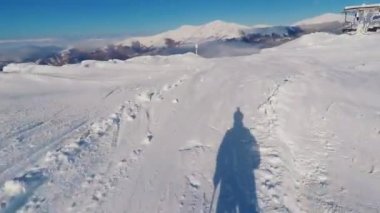 Skiing at snowed area action camera POV perspective. Skier point of view direction with visible shadow figure at Vigla - Pisoderi, Greece ski resort area at a path covered in snow.