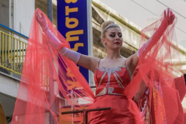 Xanthi, Yunanistan - 10 Mart 2019: Karnaval Kraliçe poz. Karnaval Kraliçe, kalabalık bir parade float gemiye sallayarak bir kırmızı elbise.