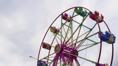 Dönme dolap multicolour kabin eğlence parkında dönüm ile aydınlatılmış. Luna Park boş dönme dolap beyaz gökyüzü arka plan şehir Festivali dönen düşük açılı görünümü.