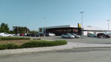 Selanik, Yunanistan - 29 Haziran 2019: Lidl Stiftung Almanya zincir süpermarket dış şirket logosu ve Yunanistan otoparkı ile. Park alanında araba ile Lidl Hellas indirim mağazası gün görünümü.