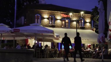 Selanik, Yunanistan - 15 Ağustos 2019: Kalabalık ve canlı buuzouki müziğinin bulunduğu ladadika bölgesi. Açık oturma ile çok ziyaret edilen yaya alanında ışıklı bir Yunan taverna gece görünümü.