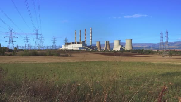 田舎の褐炭発電所広い視野を生成します ギリシャプトレマイダで褐炭の化石燃料を燃焼させて発電する発電所の晴れた日の眺め — ストック動画