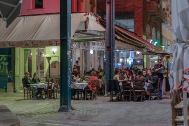 Selanik, Yunanistan - 12 Ekim 2019: Açık hava taverna restoranlarında insanların Yunan gece hayatı.