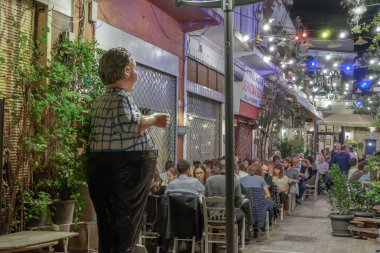 Selanik, Yunanistan - 12 Ekim 2019: Açık hava taverna restoranlarında insanların Yunan gece hayatı.