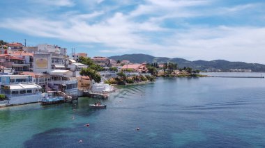 Chalkidiki, Yunan sahil köyünün insansız hava aracı görüntüsü. Düşük katlı binalar ve arka planda Porto Carras tatil beldesi bulunan Sithonia yarımadasındaki Neos Marmaras 'ın hava günü görüntüsü.