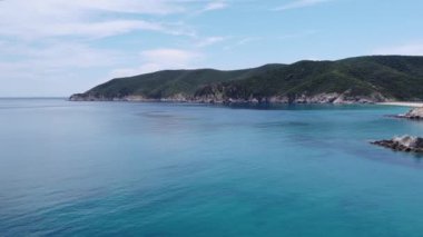 Akdeniz manzaralı plaj insansız hava aracı. Sithonia Çelkidiki Yarımadası 'nın küçük kayalık adalı yeşil tarlalardan kristal berrak su yataklarına ve şemsiyeli deniz yataklarına uzanan havası..