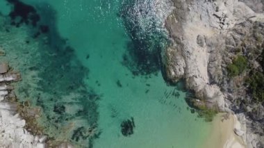 Akdeniz manzaralı plaj insansız hava aracı. Sithonia Chalkidiki yarımadasının havadan görünüşü kayalık kıyı şeridinden kristal berrak su yataklarına şemsiyeli deniz yatakları.
