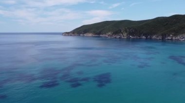 Akdeniz manzaralı plaj insansız hava aracı. Sithonia Chalkidiki yarımadasının havadan görünen yeşil tarlaları ve kristal berrak suları ile kayalık kıyı şeridi üzerinde dönüyor..