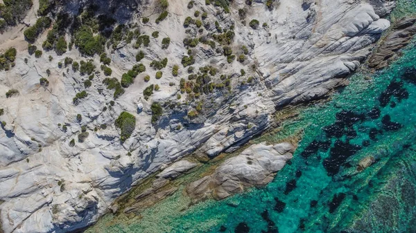 Mediterranean Greek landscape drone shot at Kavourotripes beach. Sithonia Chalkidiki peninsula aerial top view pan with rocky coastal and crystal-clear waters.