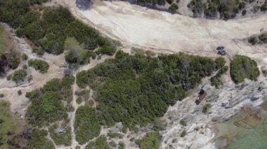 Akdeniz 'in insansız hava araçları Kavourotripes plajında yüzücülerle çekim yapıyor. Sithonia Chalkidiki yarımadası, kayalık kıyı şeridinden kristal berrak su yataklarına şemsiyeli hava manzaralı..