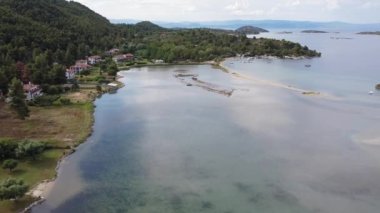 Akdeniz Yunanistan 'ın kıyı insansız hava aracı görüntüsü. Sithonia Chalkidiki yarımadasının havadan görünüşü kıyı şeridinin üzerinde yeşil plantasyon ve deniz kıyısında alçak binalarla dönüyor.