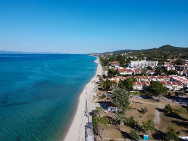 Chalkidiki, Yunanistan kıyı köyü insansız hava aracı görüntüsü. Hanioti 'nin ya da Chaniotis' in Kassandra yarımadasındaki temiz, mavi deniz kıyısındaki alçak katlı deniz manzarası..