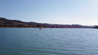 İnsansız hava aracı, sakin denizde Caique balıkçı teknelerinin üzerinde alçaktan uçuyor. Kassandra Chalkidiki yarımadasındaki Glarokavos gölünün yeşil tarlalı havadan görünüşü.