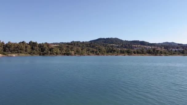 Paysage méditerranéen grec drone côtier abattu dans la région des collines recouvertes de pins. Vue aérienne du dessus de la lagune de Glarokavos à la péninsule de Kassandra Chalcidique au-dessus du rivage avec plantation verte et maisons.
