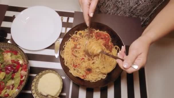 意大利意大利面配虾仁特写 放在色拉色拉丰富的桌子上 将热腾腾的意大利面海鲜放在有番茄酱的碗里 用叉子和勺子在白菜上吃 俯瞰全景 — 图库视频影像