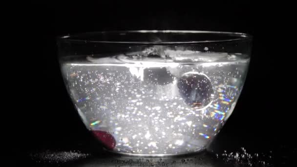 Αργή Κίνηση Των Κερασιών Που Πέφτουν Ένα Γυάλινο Μπολ Νερό — Αρχείο Βίντεο