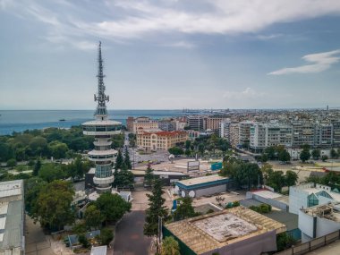 Selanik, Yunanistan 'ın boş uluslararası ticaret TIF fuarına insansız hava aracı görüntüsü. HELEXPO binasının kalabalıksız güney manzarası, OTE Telekomünikasyon Kulesi ve Beyaz Kule simgesi görünür.