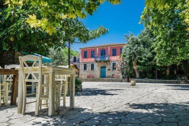 Yunanistan 'ın Chalkidiki kenti, hükümet kovid-19 tedbirleri uyguladıktan sonra tahta sandalye ve masaları boşalttı. Athytos Köy Meydanı, Kassandra Yarımadası 'nda müşterisi olmayan bir restoran..