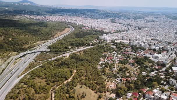 テッサロニキ ペリフェラキ内環状道路上のトラフィックのギリシャの航空機のドローン風景 街の郊外の森を通過する車とヨーロッパの高速道路の一番上のパノラマ — ストック動画