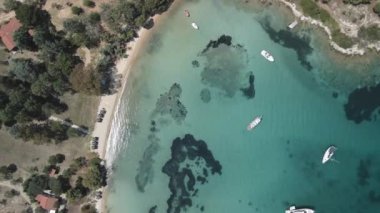 Akdeniz manzaralı plaj insansız hava aracı. Sithonia Chalkidiki yarımadasının havadan zirvesi, kristal berrak sulardan, boş teknelerle, alçak katlı kırmızı kiremit çatı evleriyle kıyı boyuna dönüyor.. 