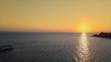 Turuncu gün batımı ve Akdeniz Yunan manzarasına insansız hava aracı vuruşu. Sithonia Chalkidiki yarımadasının açık sularda dinlenme teknesiyle kıyı üzerinde dönen hava akşamı manzarası.