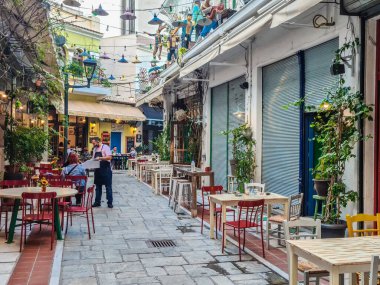 Selanik, Yunanistan açık hava taverna restoranlarında insanların yemek yediği Yunan manzarası. Bezesteni bölgesinin merkezindeki çoğunlukla boş tavernalarda daha az yemek ve içki içiliyor.